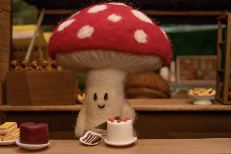 Un champignon en train de couper un gâteau